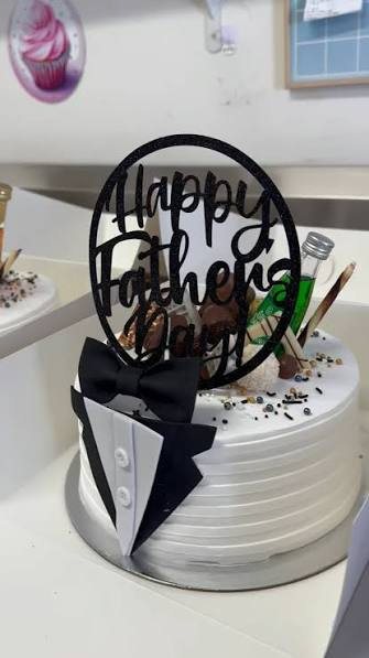 A white Father's Day cake decorated with a tuxedo, bow tie and a Happy Father's Day topper