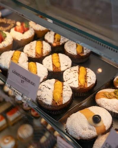 Lemon caprese cakes dusted with icing sugar in the display cabinet